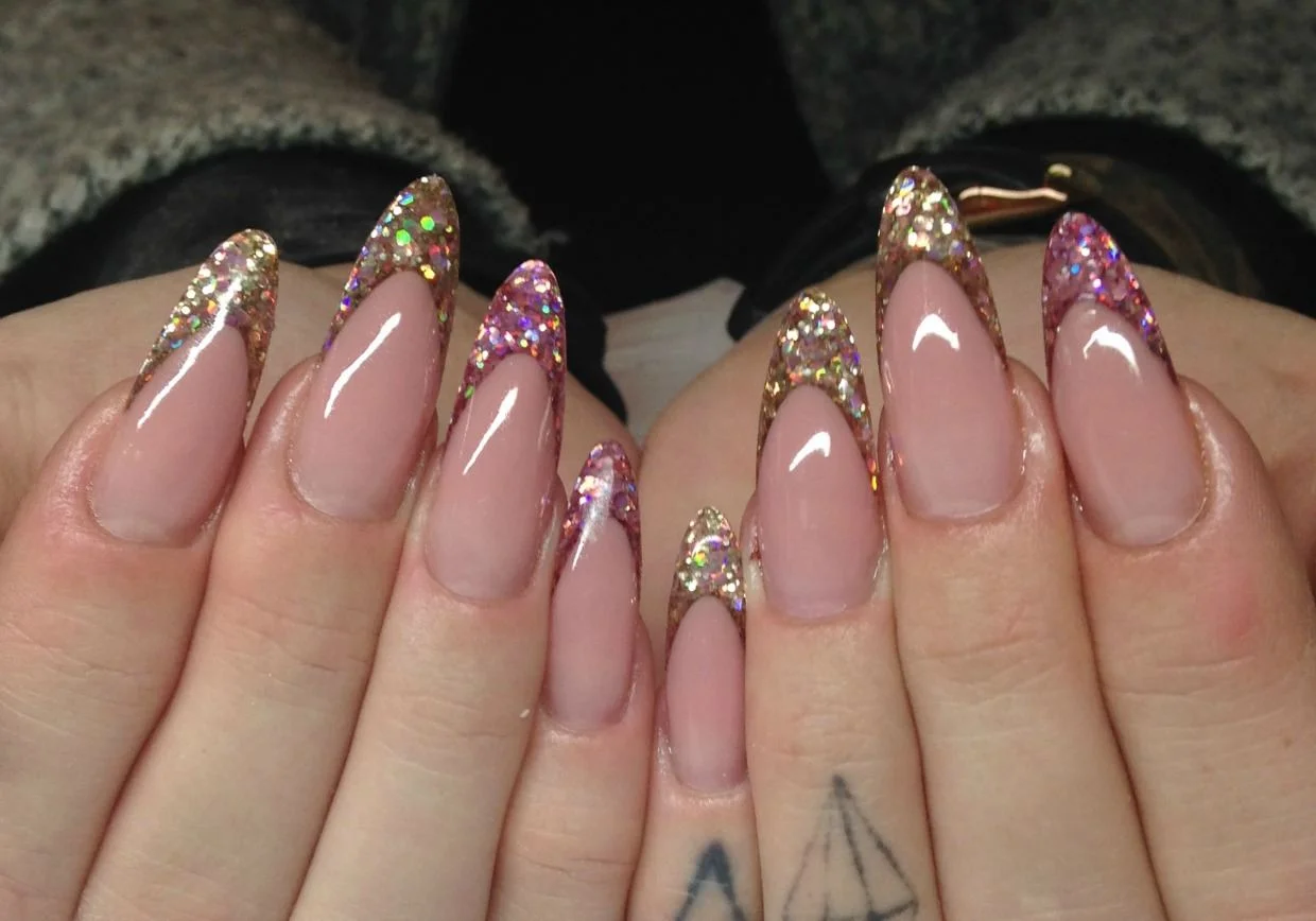 Real Nail Xpert client work — almond acrylic set with rose-gold and pink holographic glitter French tips